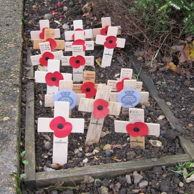Small wooden crosses were planted in the gardens of the Chandler's Ford War Memorial. At St. Boniface Church.  9 Nov 2014.