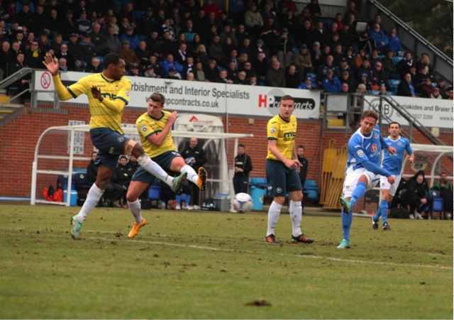 Brian Howard’s effort on goal is saved by the Torquay keeper.